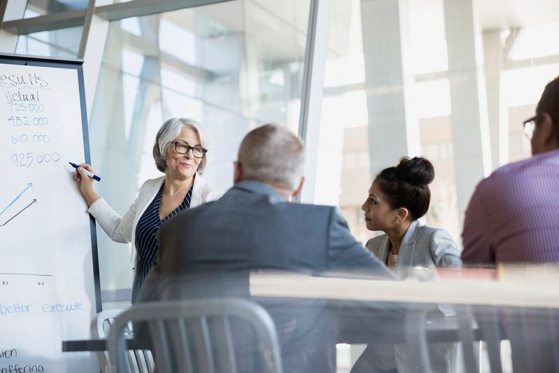 Businesswoman at whiteboard leading meeting
